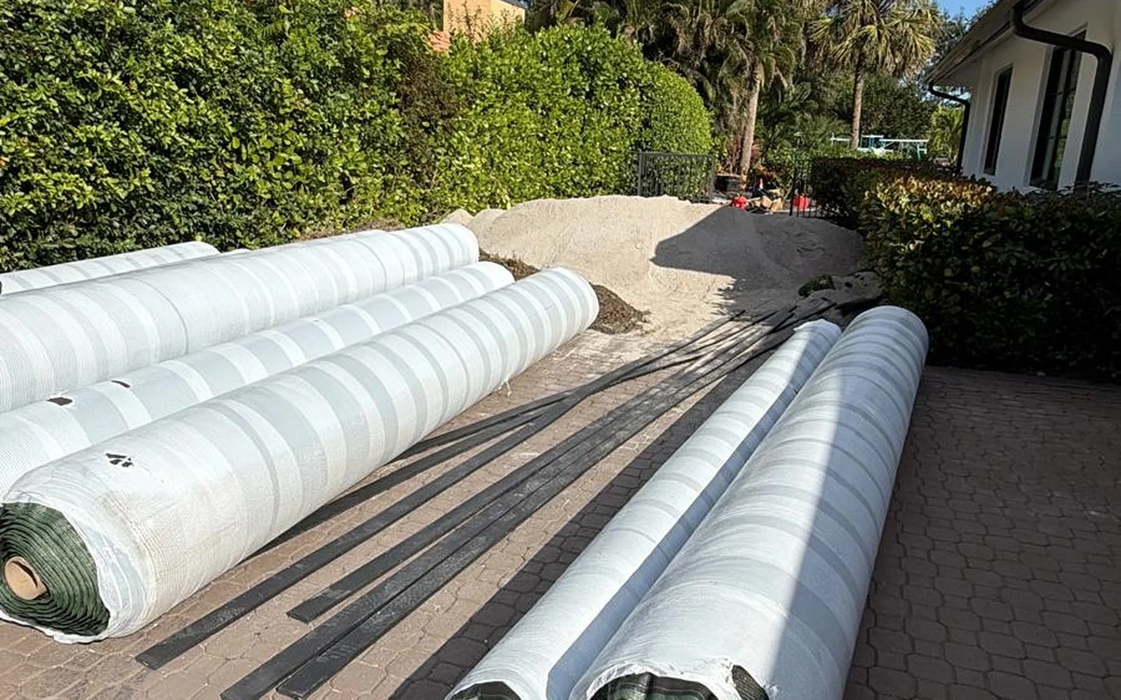 Artificial turf rolls staged beside the residence