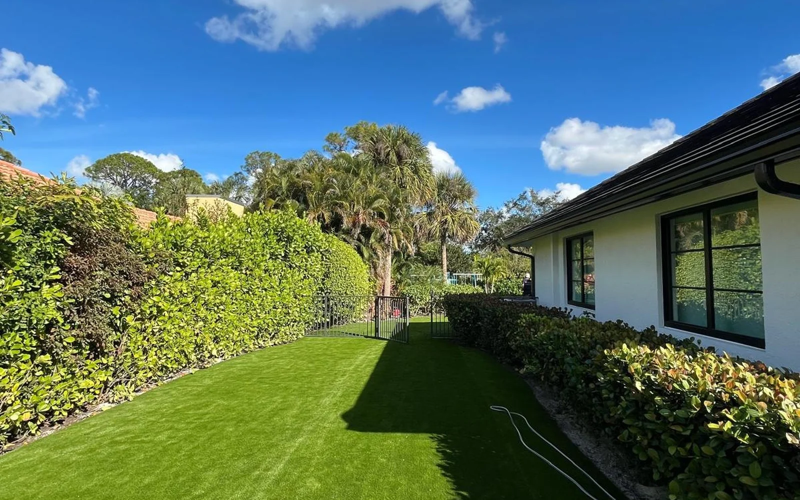 Finished artificial turf transition along the side of the residence
