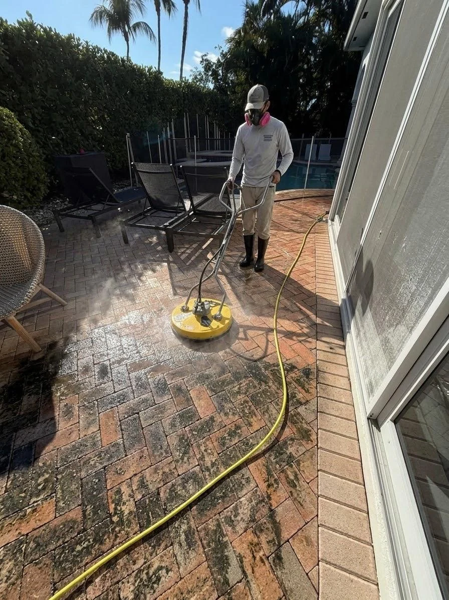 Technician using a circular surface cleaner beside a South Florida pool